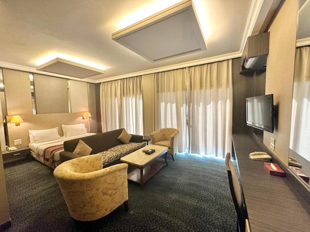 une chambre d'hôtel avec un canapé et un lit dans l'établissement Padova Hotel, à Beyrouth