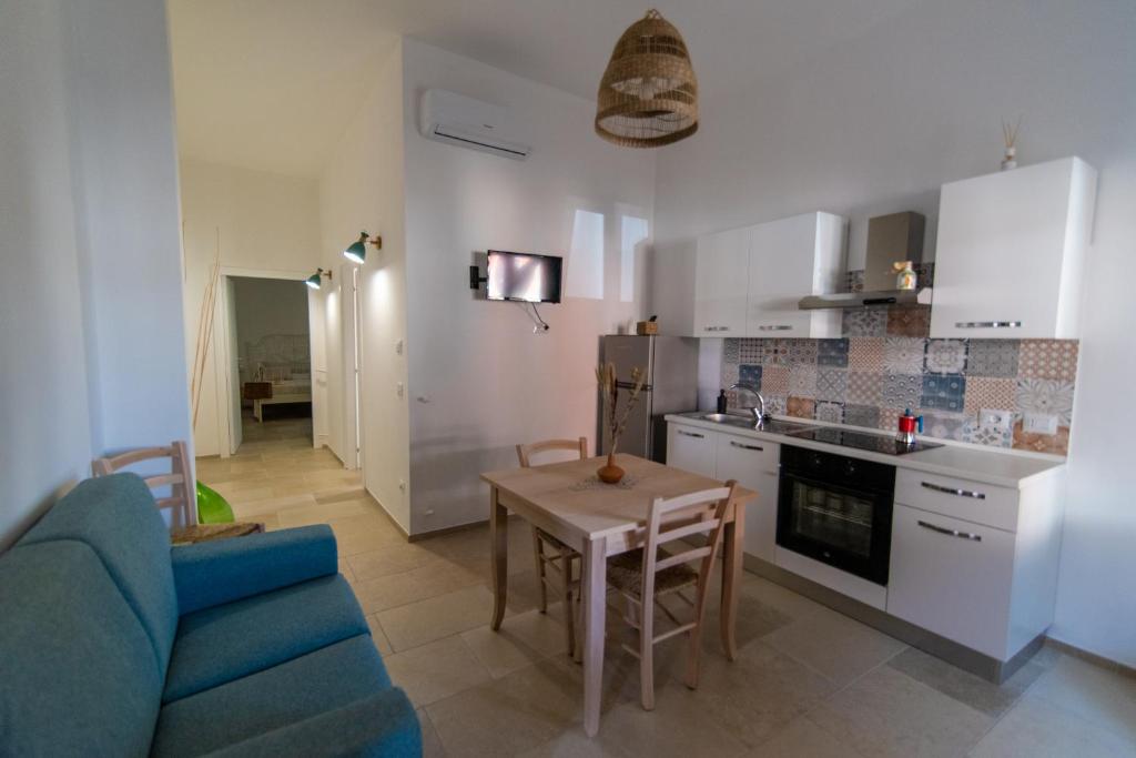 cocina y sala de estar con sofá azul y mesa en Il casalicchio for couples, en Montalbano