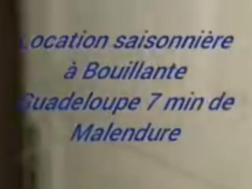 un primer plano de una señal con la ayuda a la utilización de palabras y el nombre de bombardeo en Chez Vava et Maïanne en Bouillante