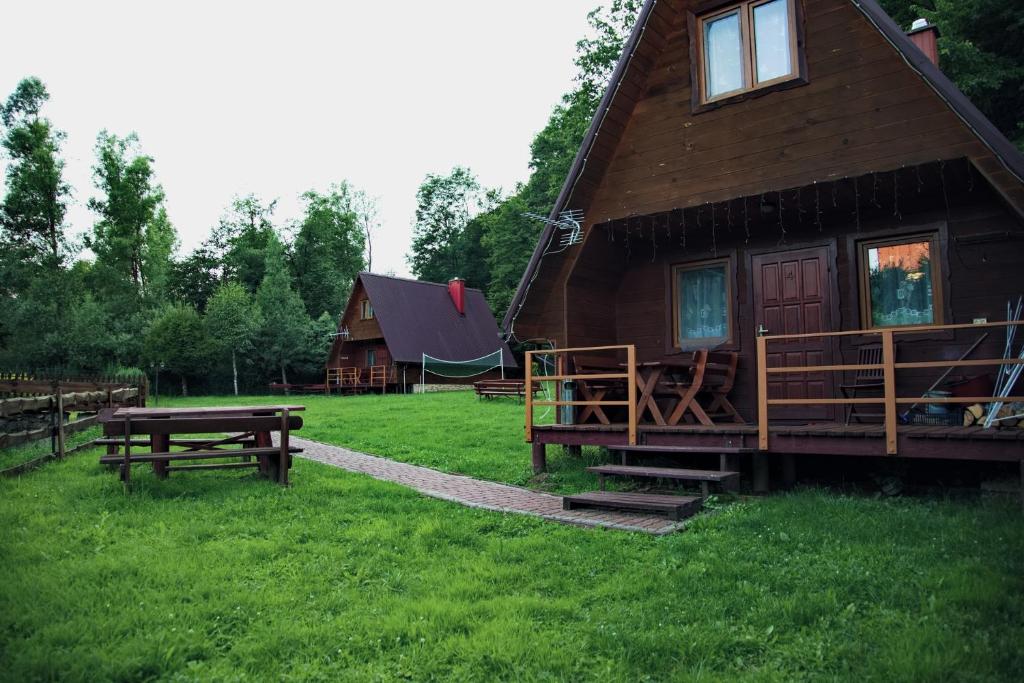 une cabane en rondins avec une table de pique-nique et un banc dans l'établissement Domki Bieszczadnik, à Hoczew