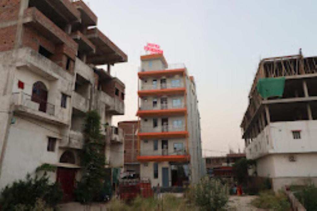 a tall apartment building next to some buildings at Hotel Friends Inn ,Jakariyapur in Gulzārbāgh