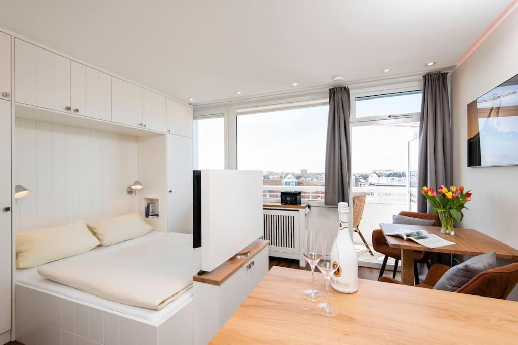 a living room with a bed and a dining room at Exklusive Wohnung im Herzen Westerlands in Westerland