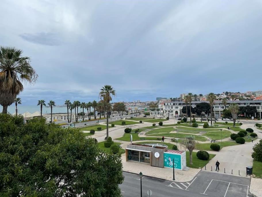 un parc avec des palmiers et un bâtiment dans l'établissement Estoril - Bay view apartment, à Estoril