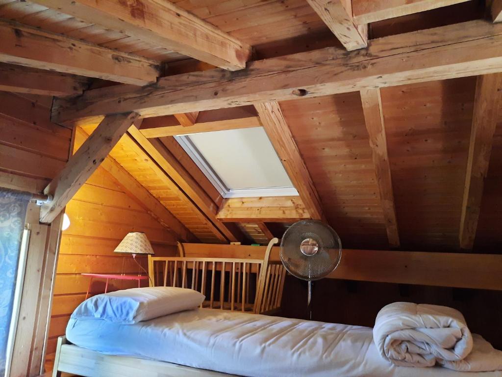 Aromas的住宿－CHALET RONDIN JURA，一间带两张床的卧室,位于木天花板的房间