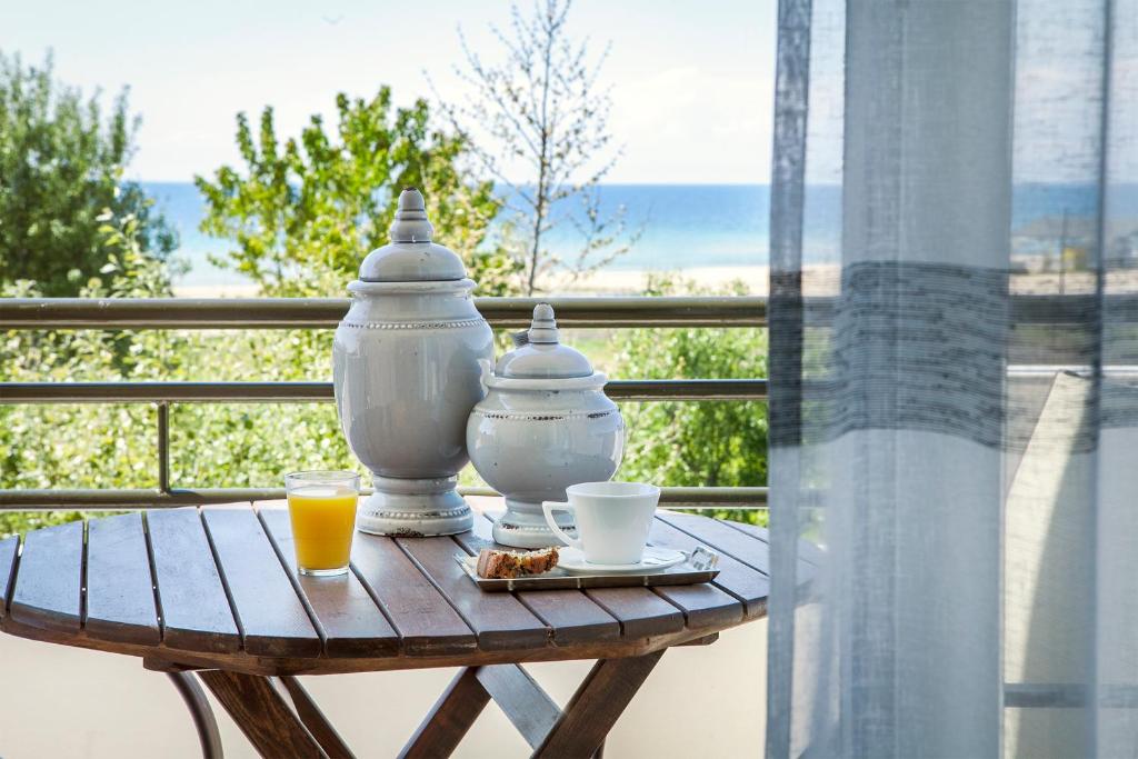 a table with two cups of coffee and juice on a balcony at Akti Retzika in Epanomi