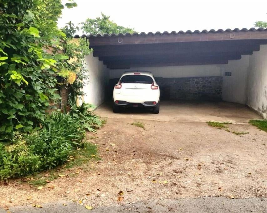 a white car is parked in a garage at Maison de Village en pierres in Le Poët