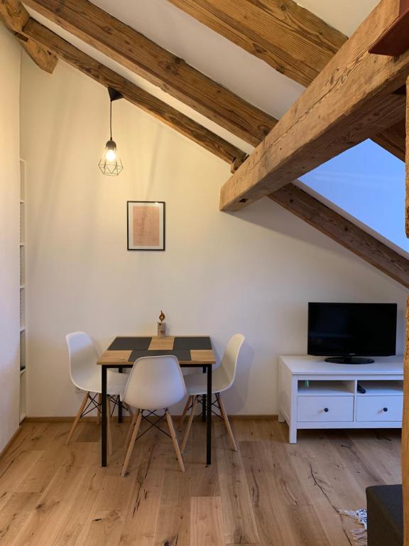 een eetkamer met een tafel en stoelen en een tv bij Zentrale 1-Zimmer-Wohnung in der Altstadt in Landsberg am Lech