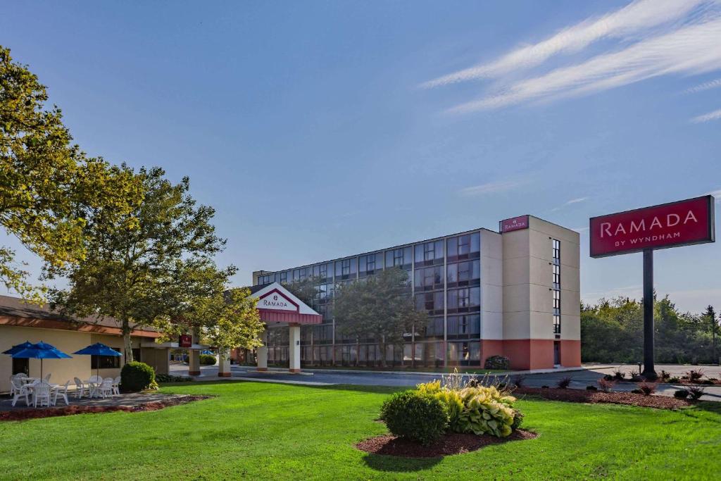 a hotel with a lawn in front of a building at Ramada by Wyndham West Atlantic City in West Atlantic City