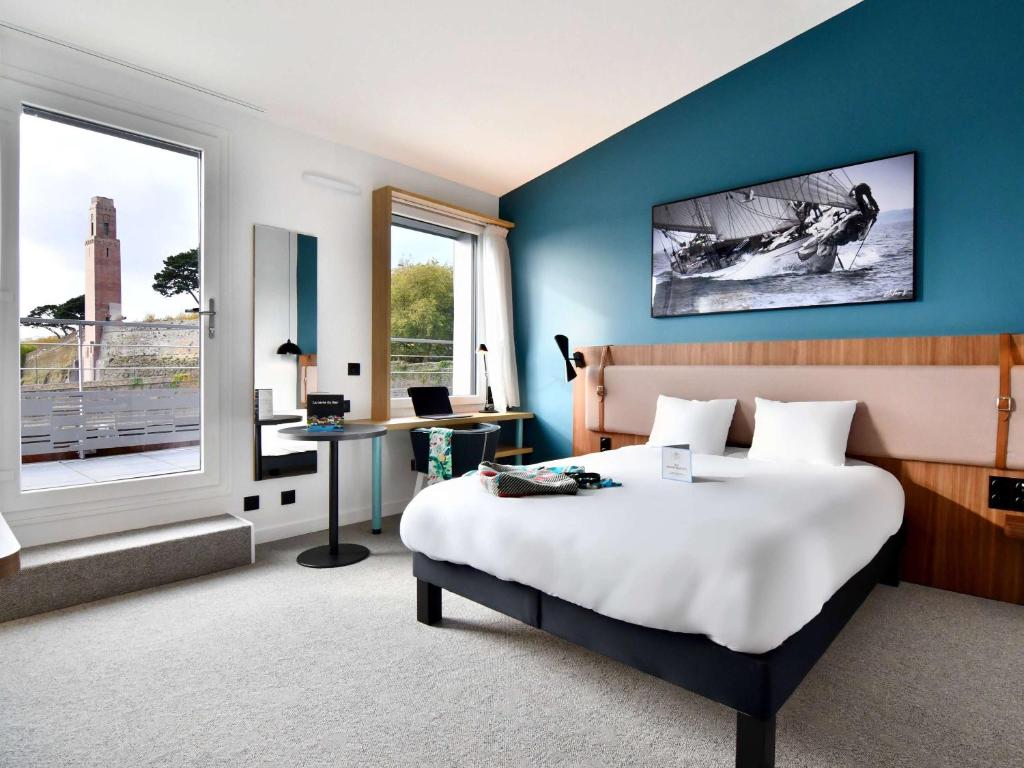 1 dormitorio con cama, escritorio y ventana en ibis Styles Brest Centre Port, en Brest