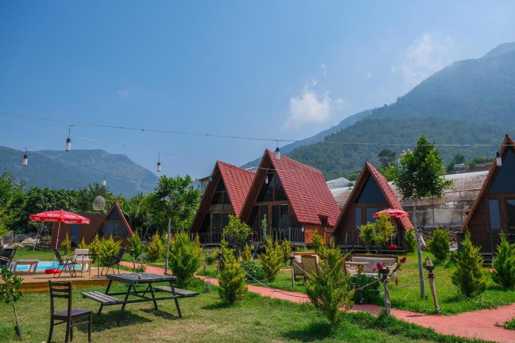 a group of cottages with mountains in the background at karaöz lighthouse bungalow in Kumluca