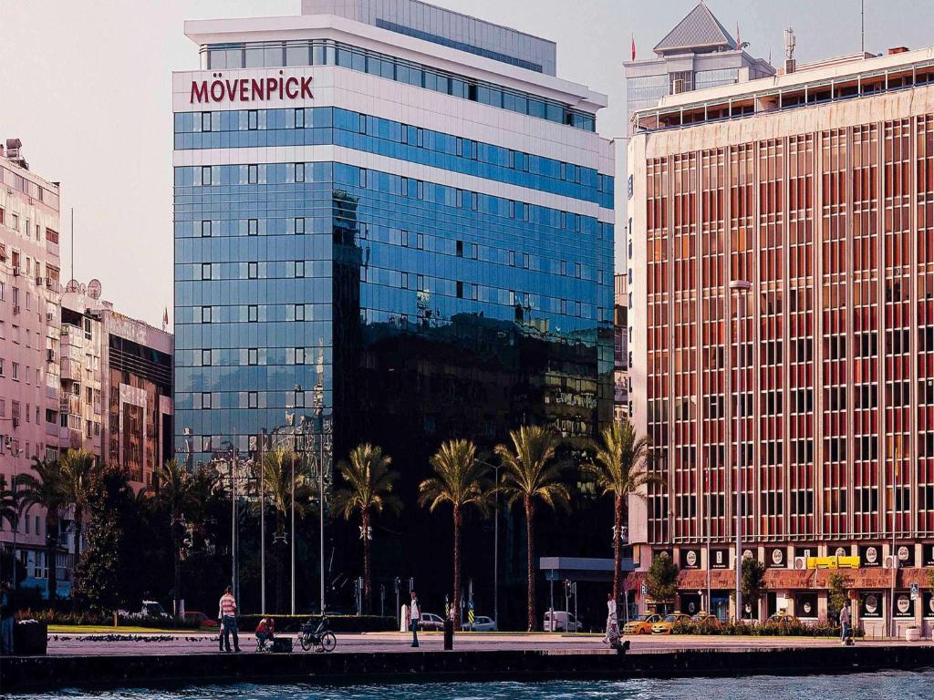 a large building with a sign on the side of it at Mövenpick Hotel Izmir in İzmir