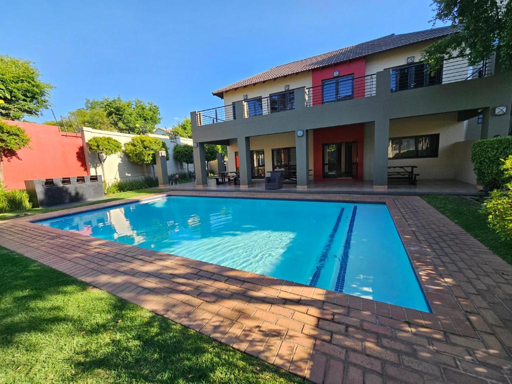 a swimming pool in front of a house at Tevin Nest in Sandton