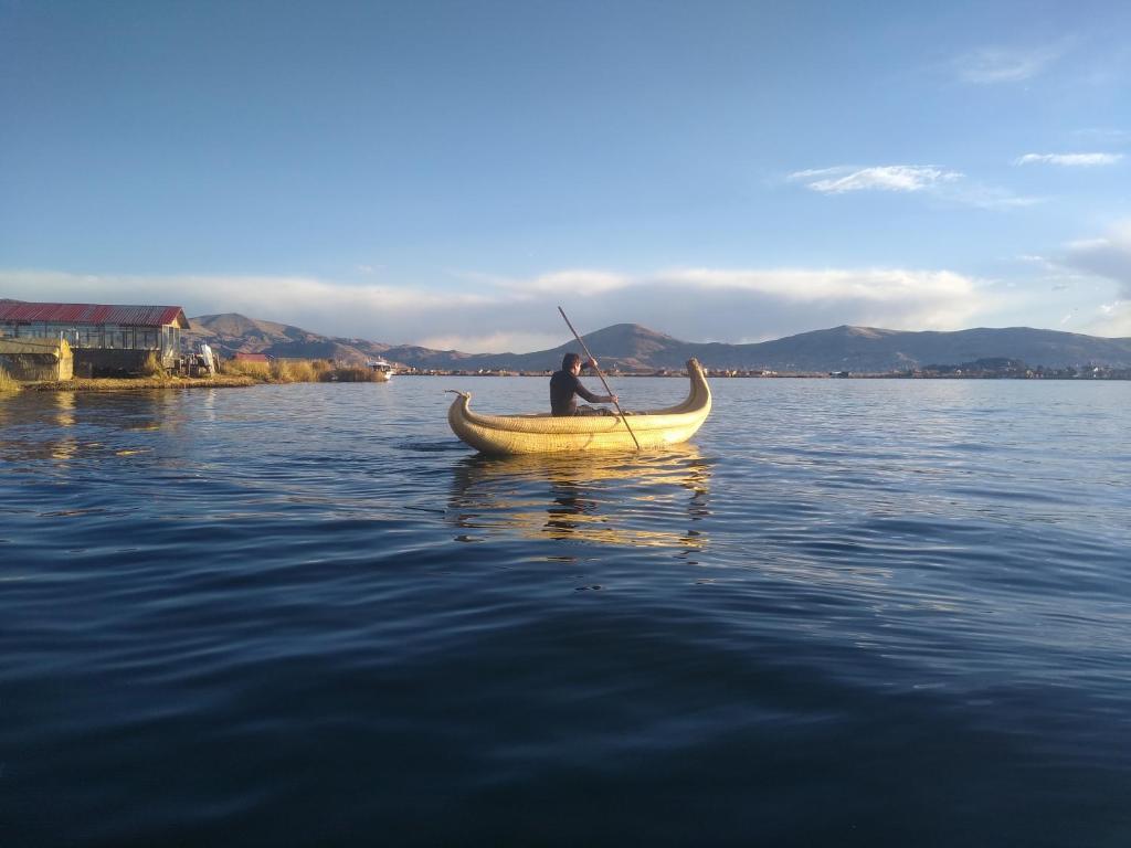 Un uomo in canoa sull'acqua di Uros Titicaca Ayni lodge a Puno