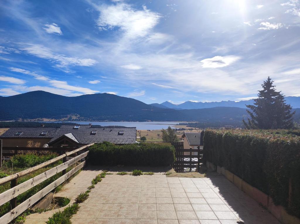une passerelle avec vue sur le lac et les montagnes dans l'établissement Appartement les Angles, aux Angles