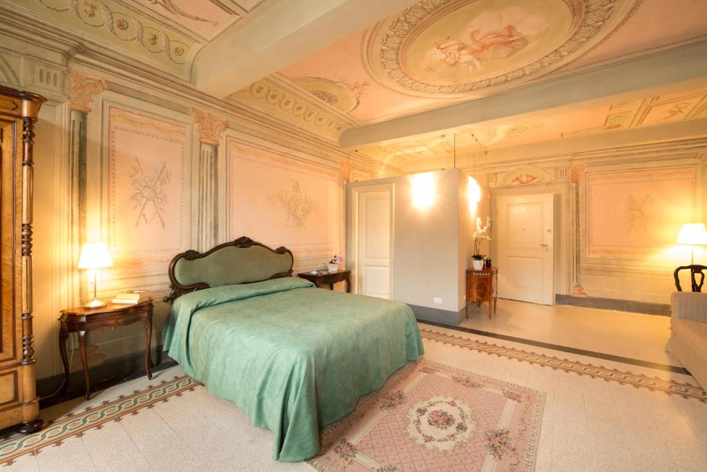 a bedroom with a bed with a green blanket at Palazzo Piazza Mazzini in Pescia