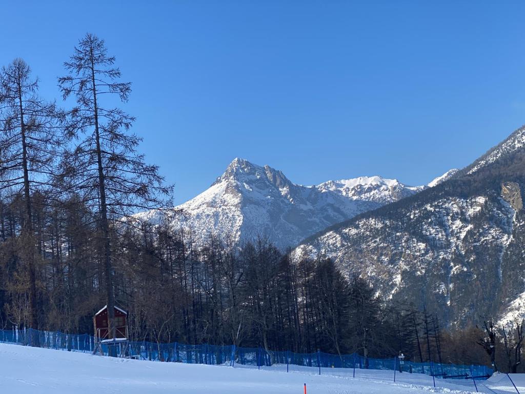 a snow covered mountain with a house in the foreground at Bardo Escape in Bardonecchia