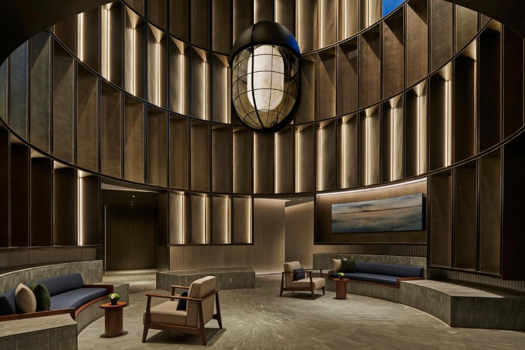 a lobby with couches and a pendant light at Artyzen NEW BUND 31 Shanghai in Shanghai