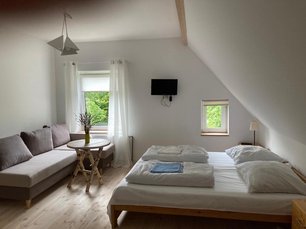 ein weißes Schlafzimmer mit einem Bett und einem Sofa in der Unterkunft Przystawy Agroturystyka in Malechowo