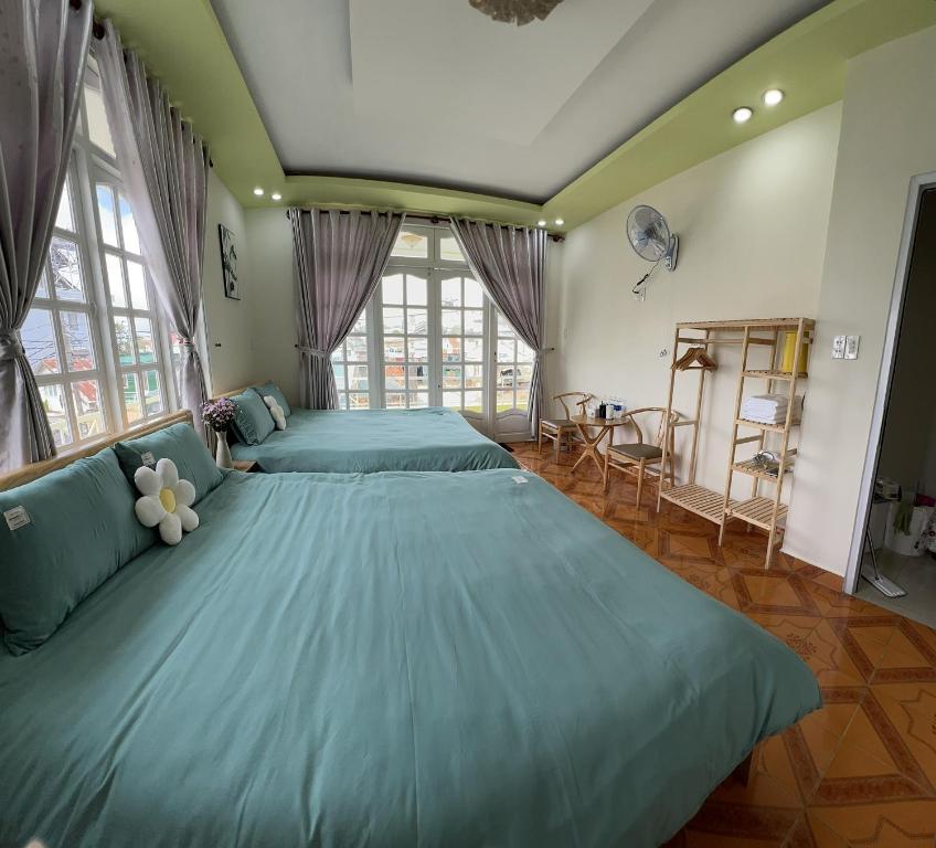 1 Schlafzimmer mit 2 großen Betten mit blauer Bettwäsche in der Unterkunft Nhà Xanh Bơ in Da Lat