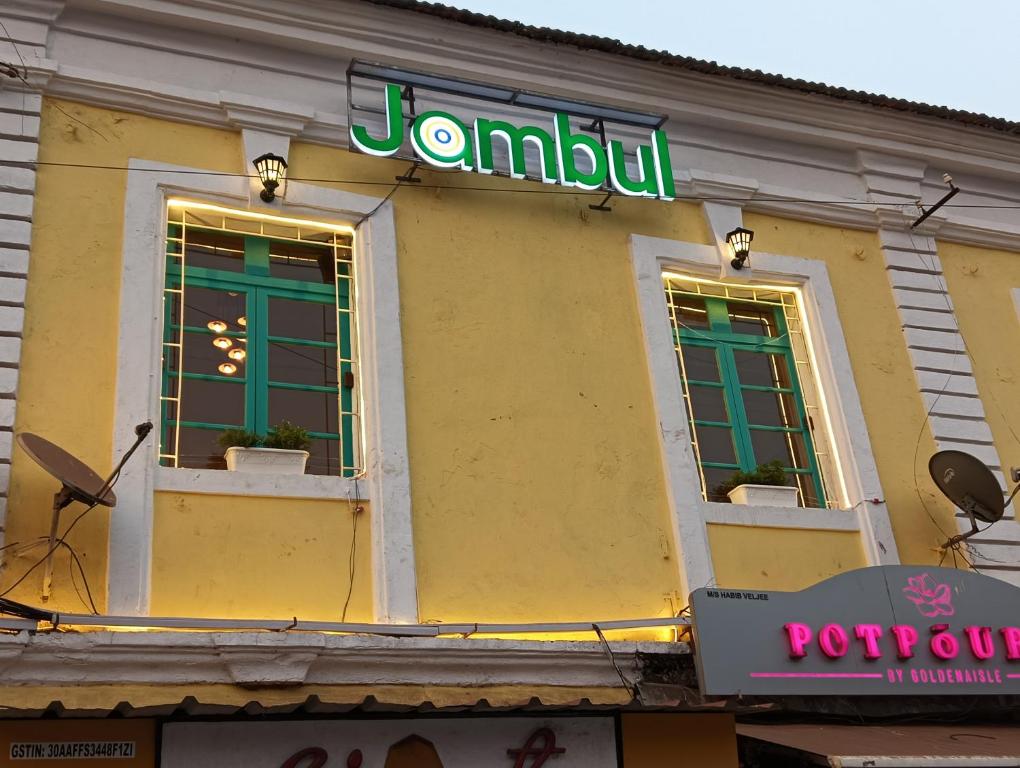a sign on the side of a building with windows at Jambul House in Panaji