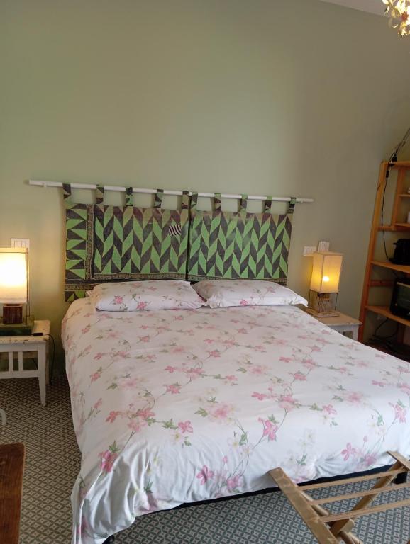 um quarto com uma cama grande e flores cor-de-rosa em LA LIMONAIA em Racale