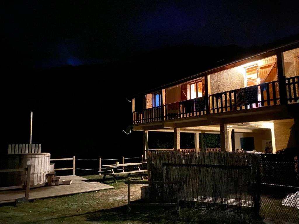 a house at night with the lights on at Les MARMOTTES pour 12 avec bain nordique privatif in Camous