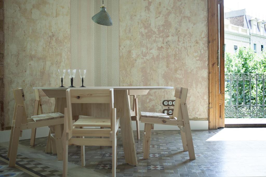 a dining room table and chairs with a table and a window at yök Casa Cultura in Barcelona