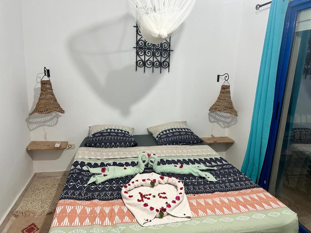 ein Schlafzimmer mit einem Bett mit einer Decke darauf in der Unterkunft Appartement MANEL in Mezraya