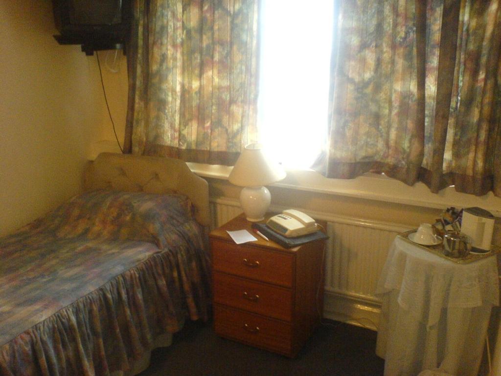 モントゴメリーにあるDolforwyn Hallのベッドルーム1室(ベッド1台、ランプ、窓付)