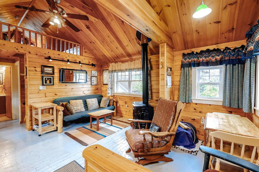 a living room of a log cabin with a couch and chair at K1 Cottage in Greenville