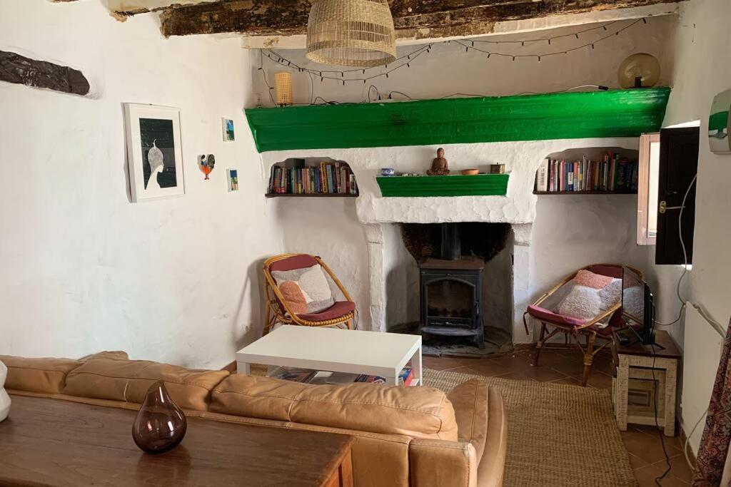sala de estar con sofá y chimenea en Casa Sin Numero, an authentic village house, en Comares