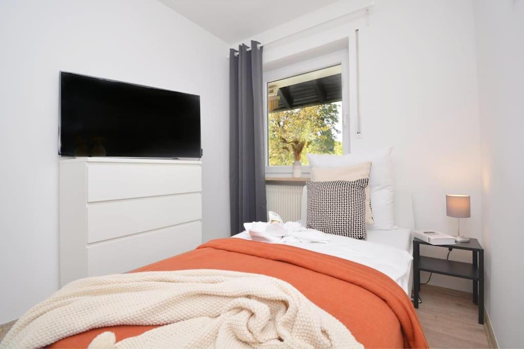 a bedroom with a bed and a flat screen tv at BA01-RI Apartment bei Bamberg in Reckendorf
