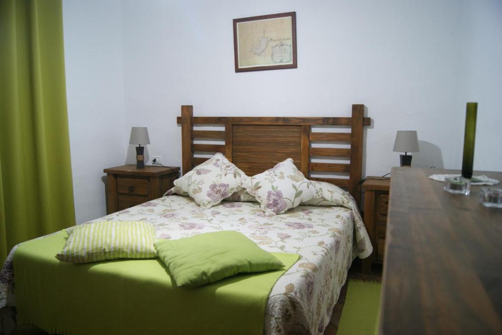 1 dormitorio con cama con almohadas y mesa en Casas del Monte, en Valverde