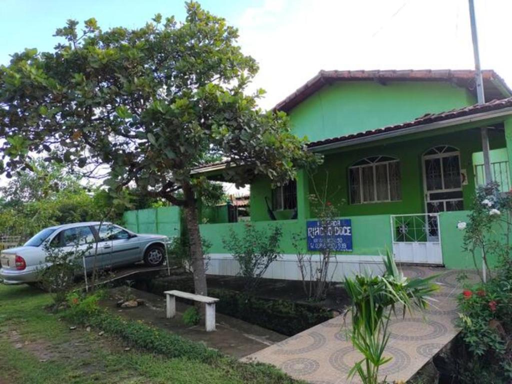 een groen huis met een auto ervoor geparkeerd bij Pousada Riacho Doce - Curimataí - Buenópolis - MG in Curumatahy