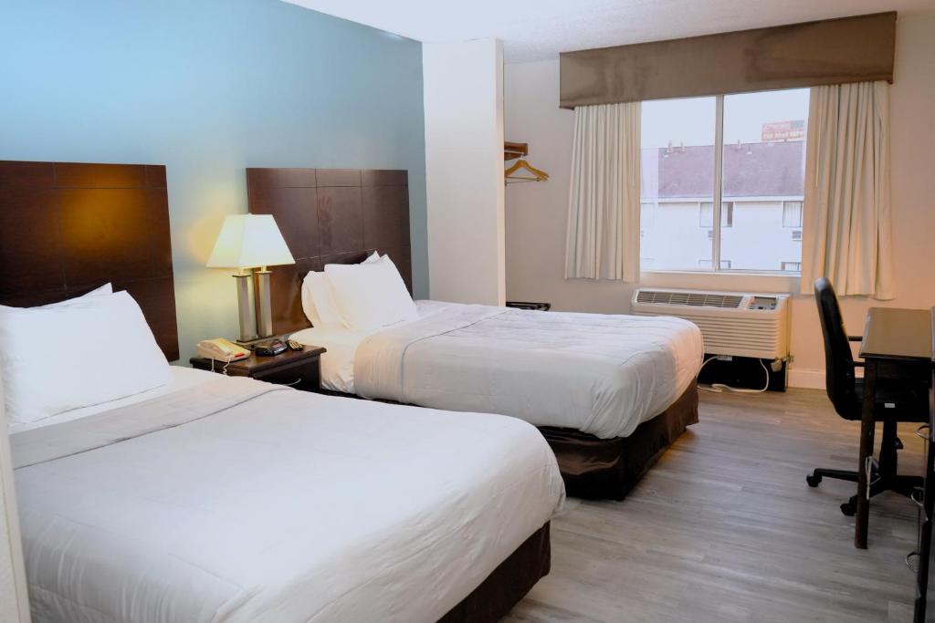 een hotelkamer met 2 bedden en een raam bij Copley Inn & Suites, Copley - Akron in Akron