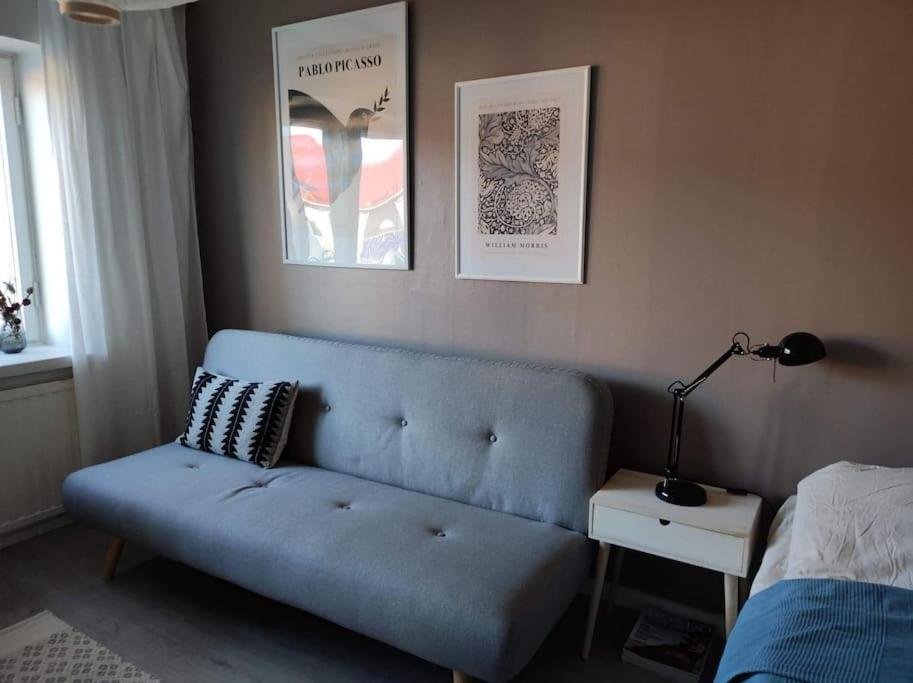 ein Wohnzimmer mit einem blauen Sofa und einem Bett in der Unterkunft Spacious and charming studio in Rovaniemi