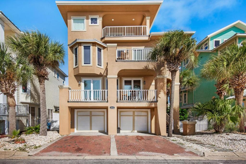 une maison avec des palmiers devant elle dans l'établissement Tequila Sunrise, à Pensacola Beach