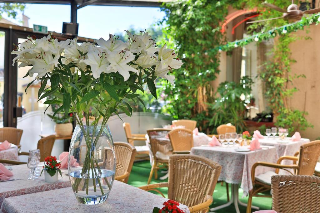 un jarrón lleno de flores blancas sentado en una mesa en Logis Le Relais Imperial, en Saint-Vallier-de-Thiey