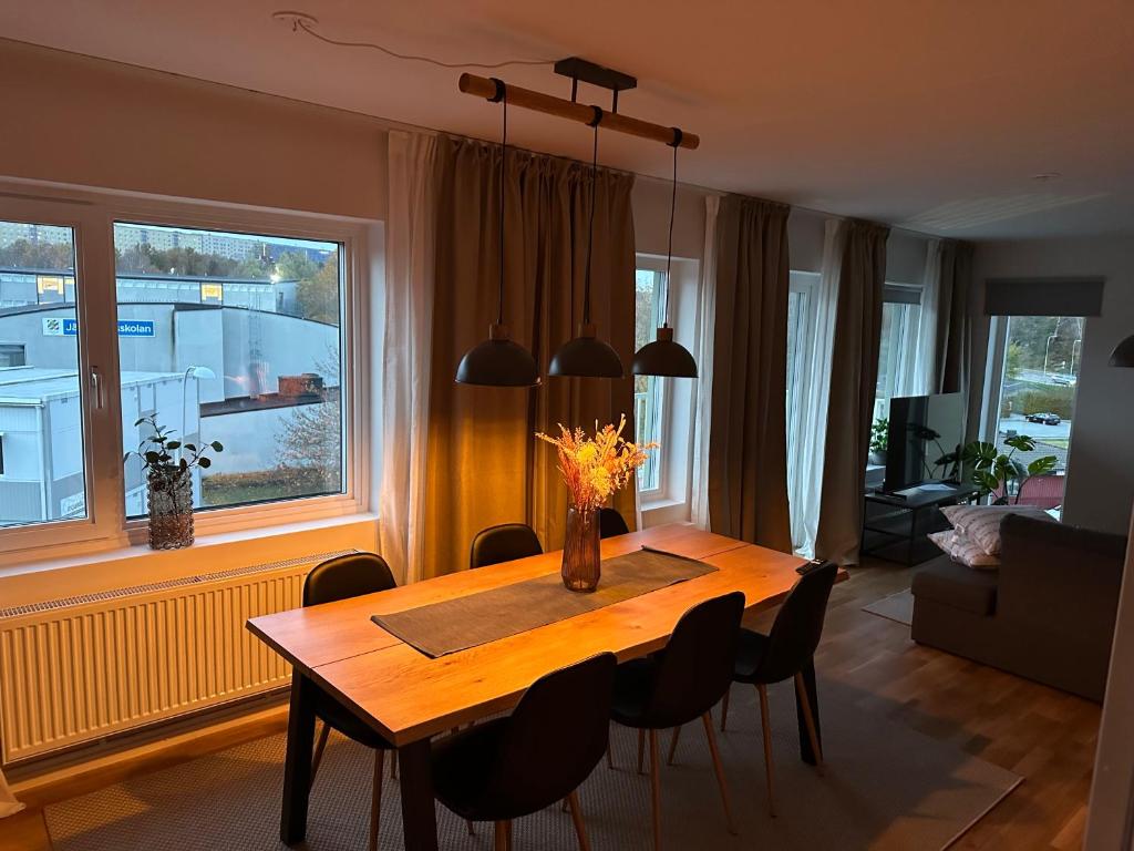 a dining room table with chairs and a large window at Feels Like Home in Gothenburg