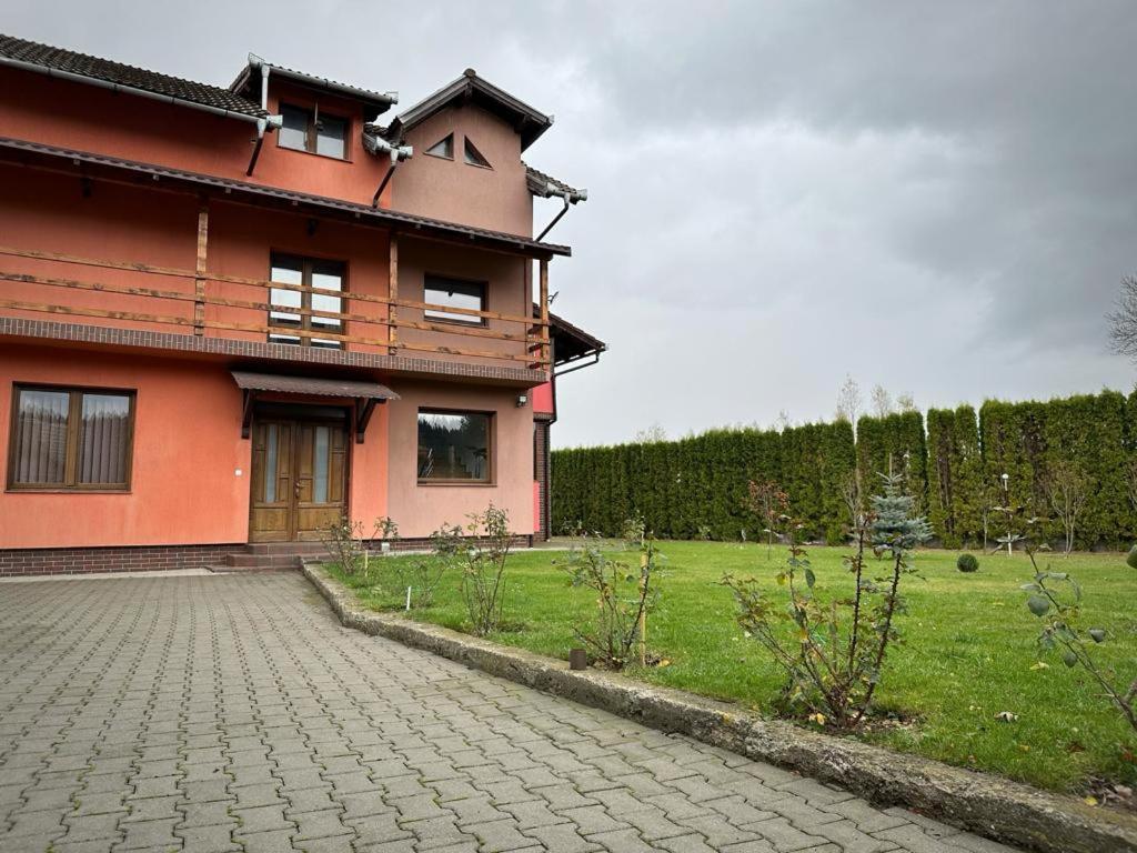 ein Haus mit einer steinernen Einfahrt davor in der Unterkunft Pensiunea Floro in Întorsura Buzăului