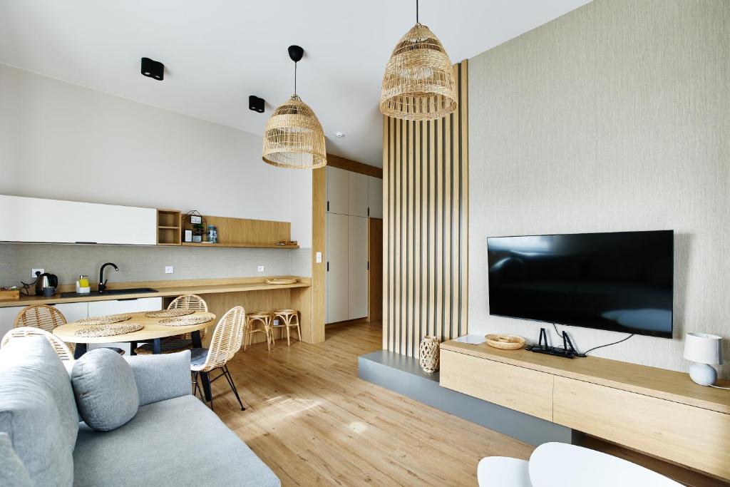 een woonkamer met een bank en een tv bij Resort Zacisze Apartamenty in Konopnica
