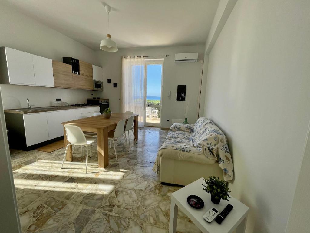 a kitchen and a living room with a table and a couch at La casa di Felice [Milazzo, Tono] in Milazzo