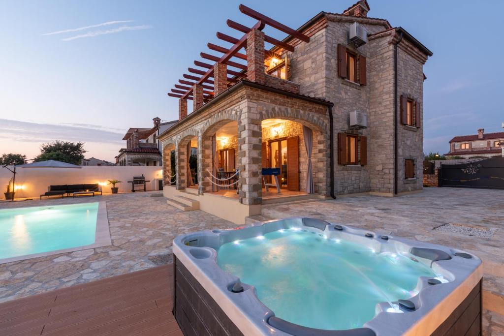an outdoor hot tub in front of a house at Vila Majda in Čabrunići