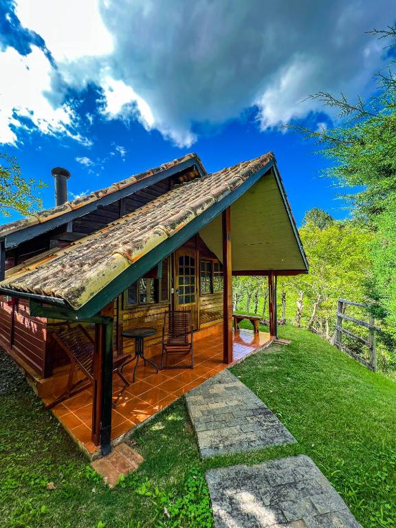a small house with a roof on a green lawn at Pousada Olivier da Montanha in Santo Antônio do Pinhal