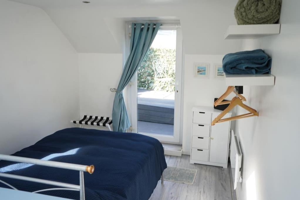sypialnia z niebieskim łóżkiem i oknem w obiekcie Cozy 1 Bed Retreat - Amlwch w mieście Amlwch