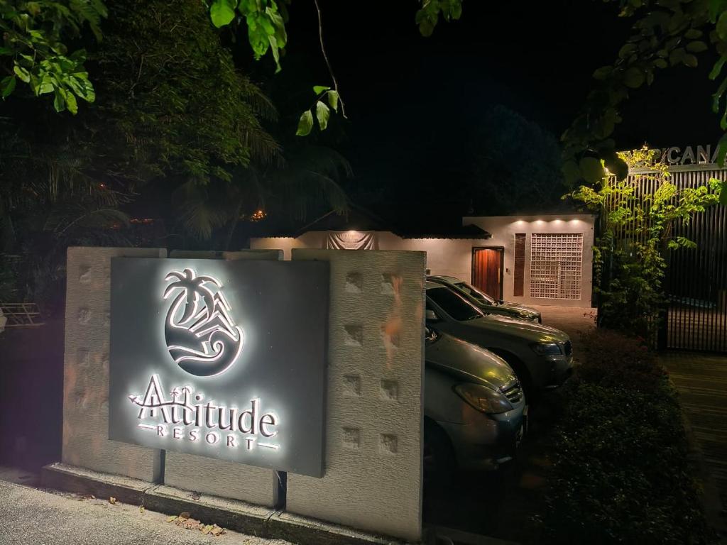 a sign for an altitude accessories at night at Attitude Resort Langkawi in Pantai Cenang