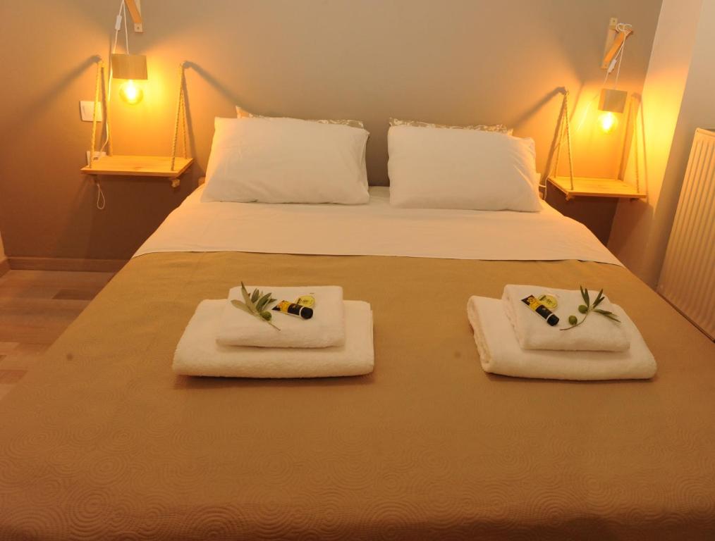 een bed met twee handdoeken met bloemen erop bij Delphic moments - Sunny app 3BR, 2BA with view in Delfoi