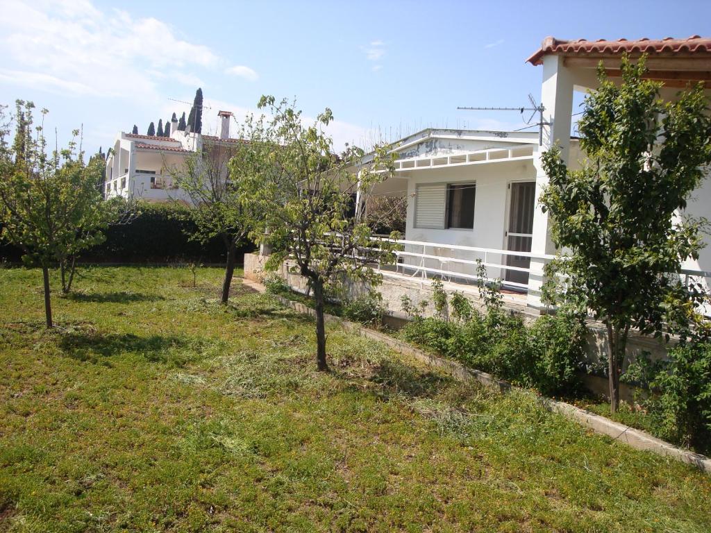 a yard with trees in front of a house at Three Bedroom Country House in Magoúla