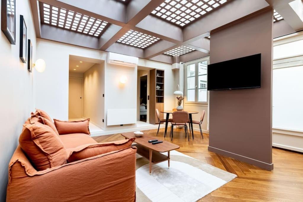 un salon avec un canapé et une télévision dans l'établissement Loft Unique - Opéra / Palais Royal - 2 chambres, à Paris