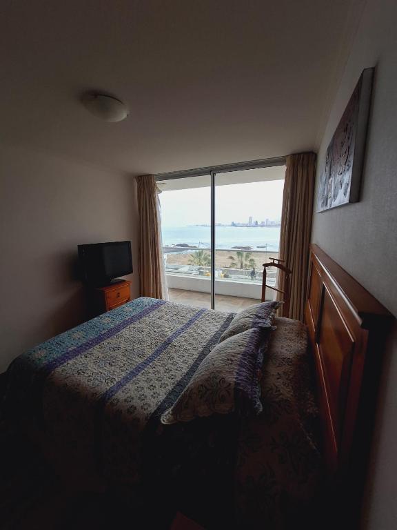 een slaapkamer met een bed en uitzicht op de oceaan bij Nautilus vista al mar in Iquique